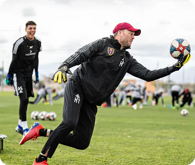 Soccer goalkeeper diving to save the ball during outdoor training session