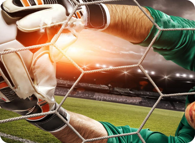 Close-up of a goalkeeper in green kit catching a ball in the net during a dramatic stadium match