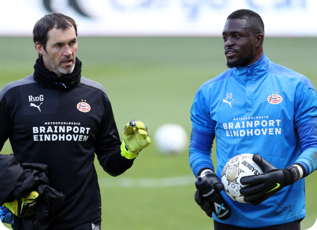 PSV Eindhoven goalkeeper coach and goalkeeper in conversation during training