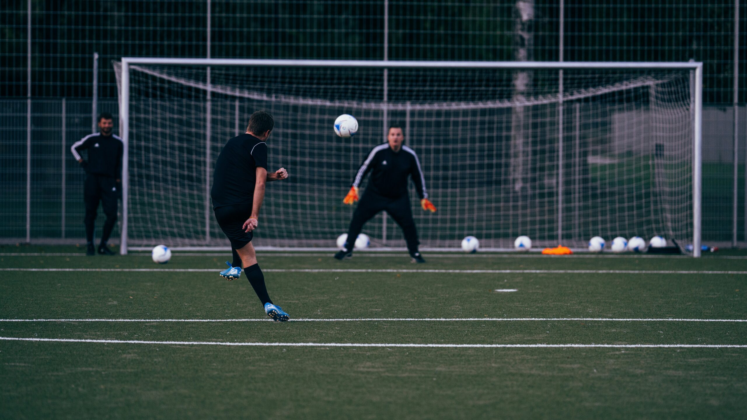 goalkeeper is in position, focused on a player taking a shot on goal